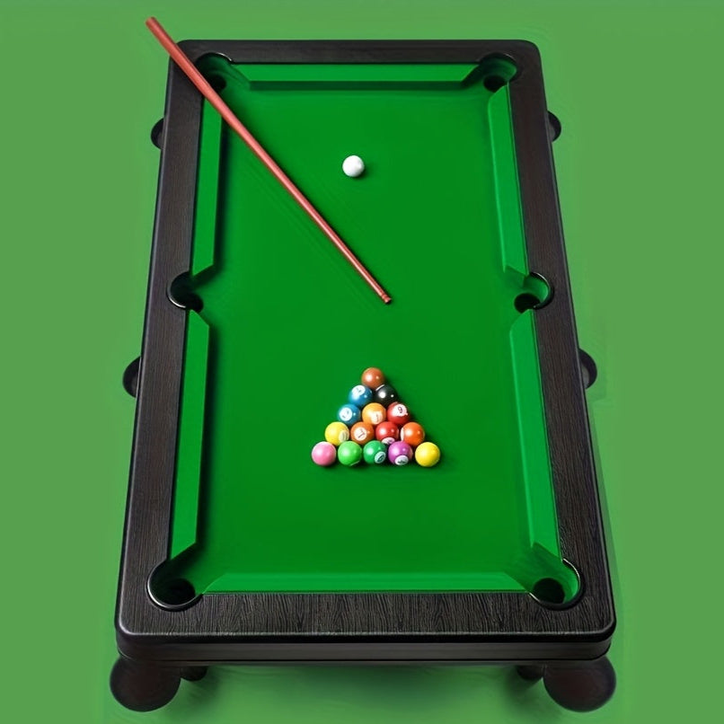 Miniature pool table with balls and cue on a green background